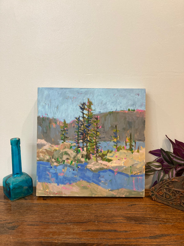 Painting of a landscape with trees and water on a wooden surface.