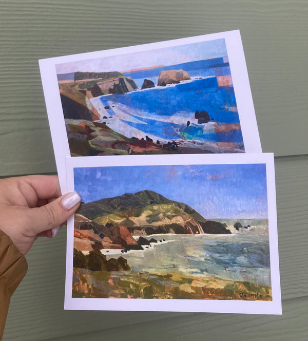 Two scenic postcards held by a hand against a gray background