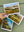 Hand holding three landscape postcards on a green surface