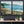 Two landscape paintings on a wall with decorative elements below.
