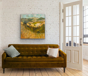 Landscape painting on wall above gold velvet couch