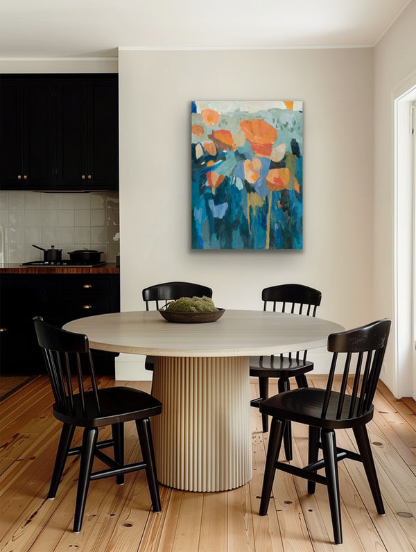 Dining area with a round table and black chairs, featuring a colorful abstract painting on the wall.