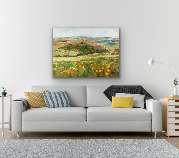 Living room with a gray sofa, colorful pillows, and a painting of a landscape on the wall.