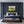 Modern bedroom with dark blue paneled walls, a bed with blue and beige bedding, and a painting above the bed.