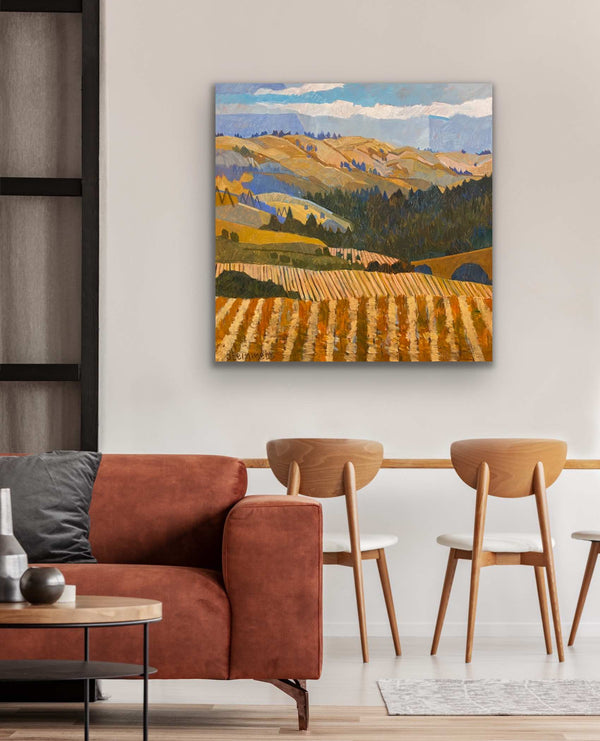 a room with a Vineyard painting above some chairs